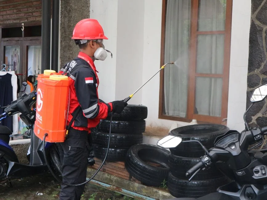 From above anonymous housekeeper in yellow rubber gloves spraying cleaner to chrome water faucet in bathroom